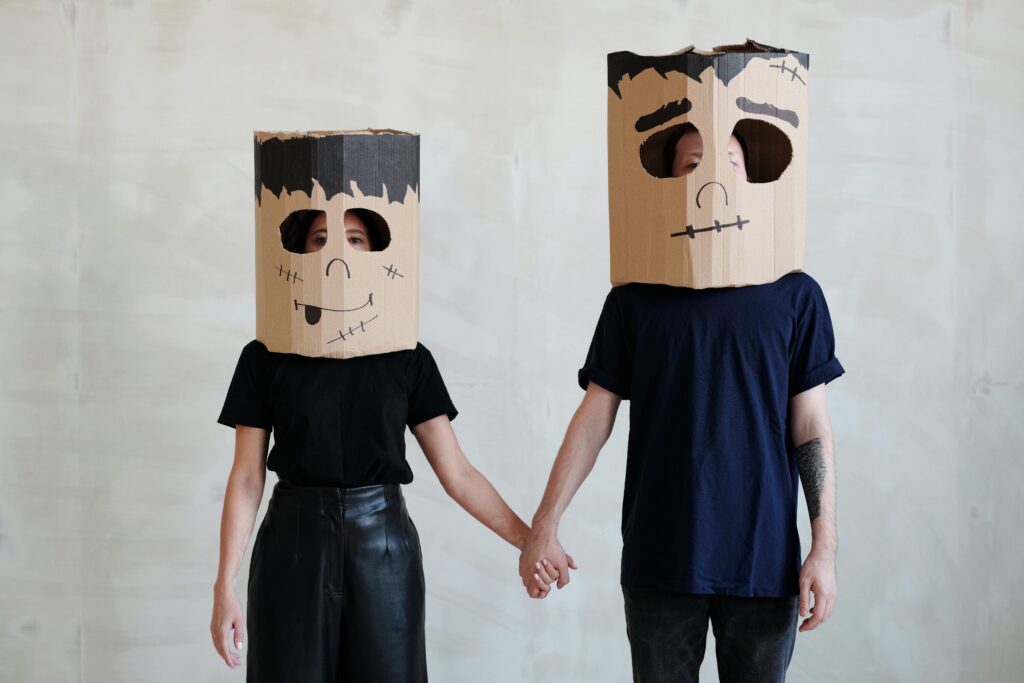 A Couple Wearing DIY Cardboard Box Mask While Holding Each Other's Hands, cute Halloween costume